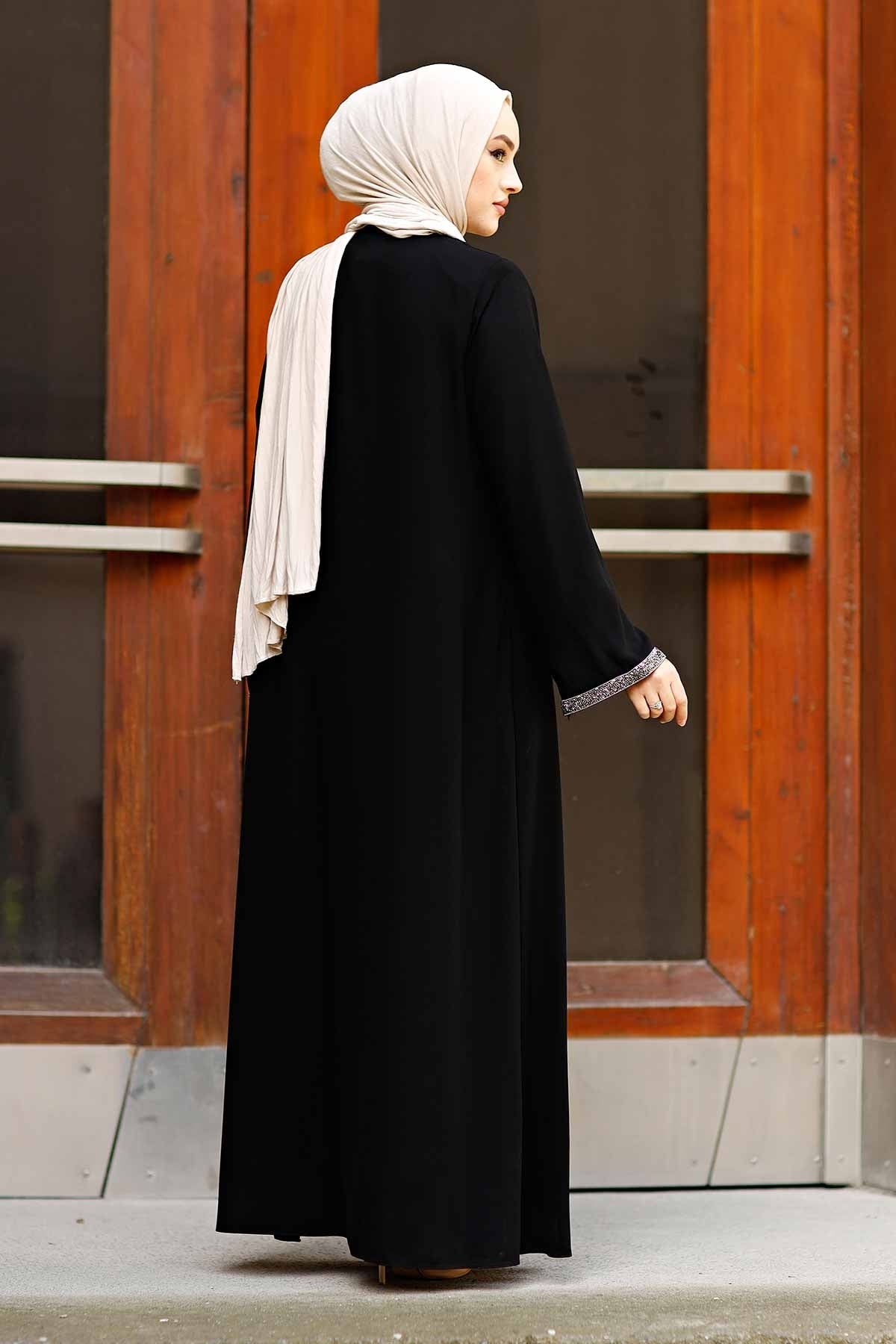 Detail of black abaya front zipper with decorative tassel pull and stone border