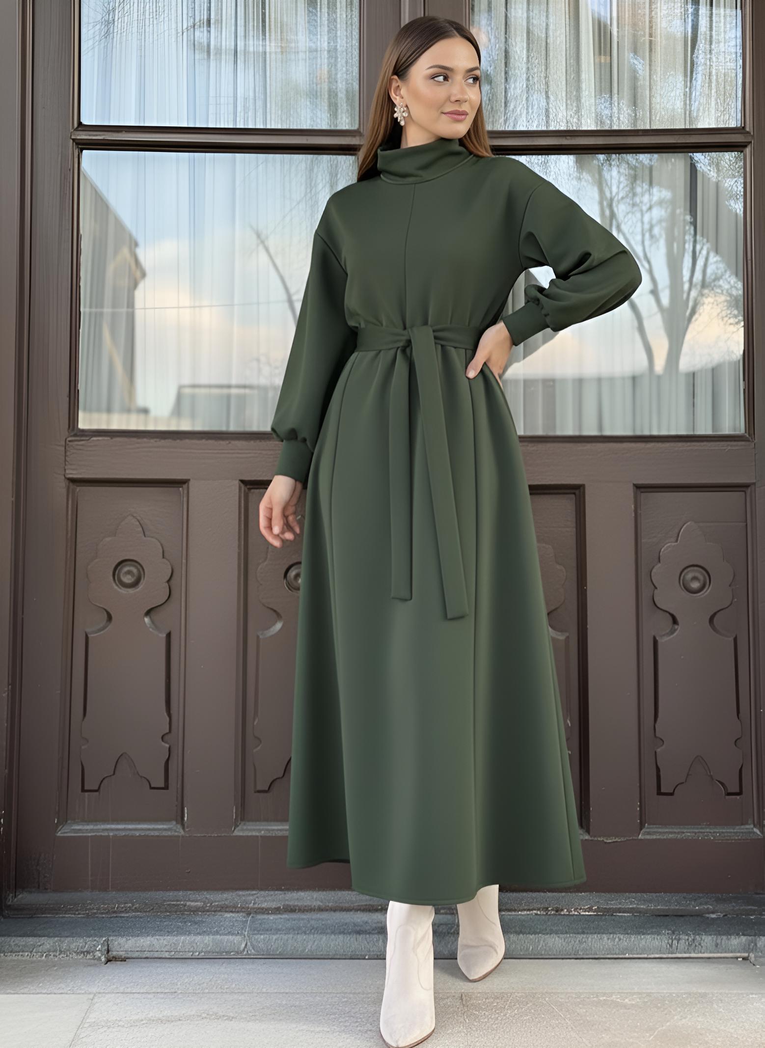 Green winter maxi dress showing high turtleneck neckline and self-tie waist belt
