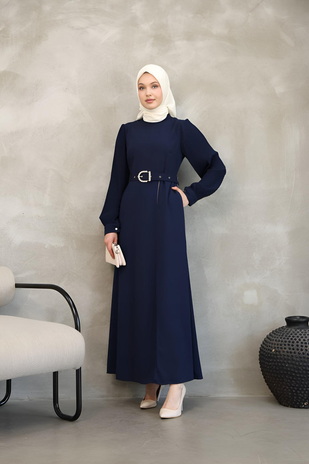 Close-up of pearl-embellished buckle belt on a navy two-tone maxi dress