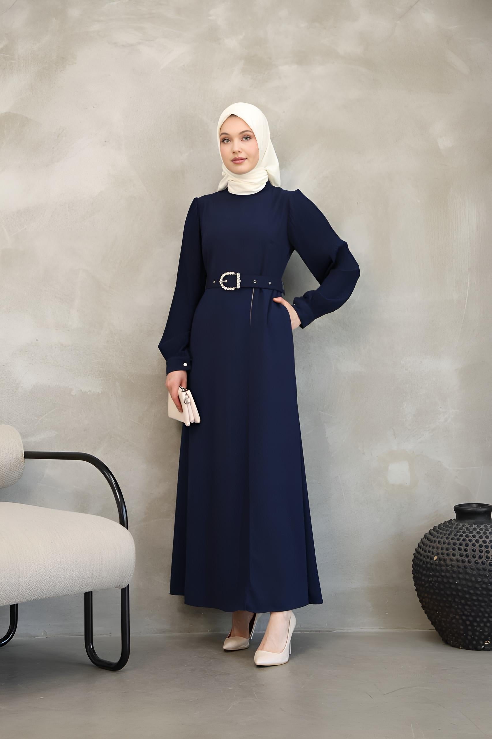 Close-up of pearl-embellished buckle belt on a navy two-tone maxi dress