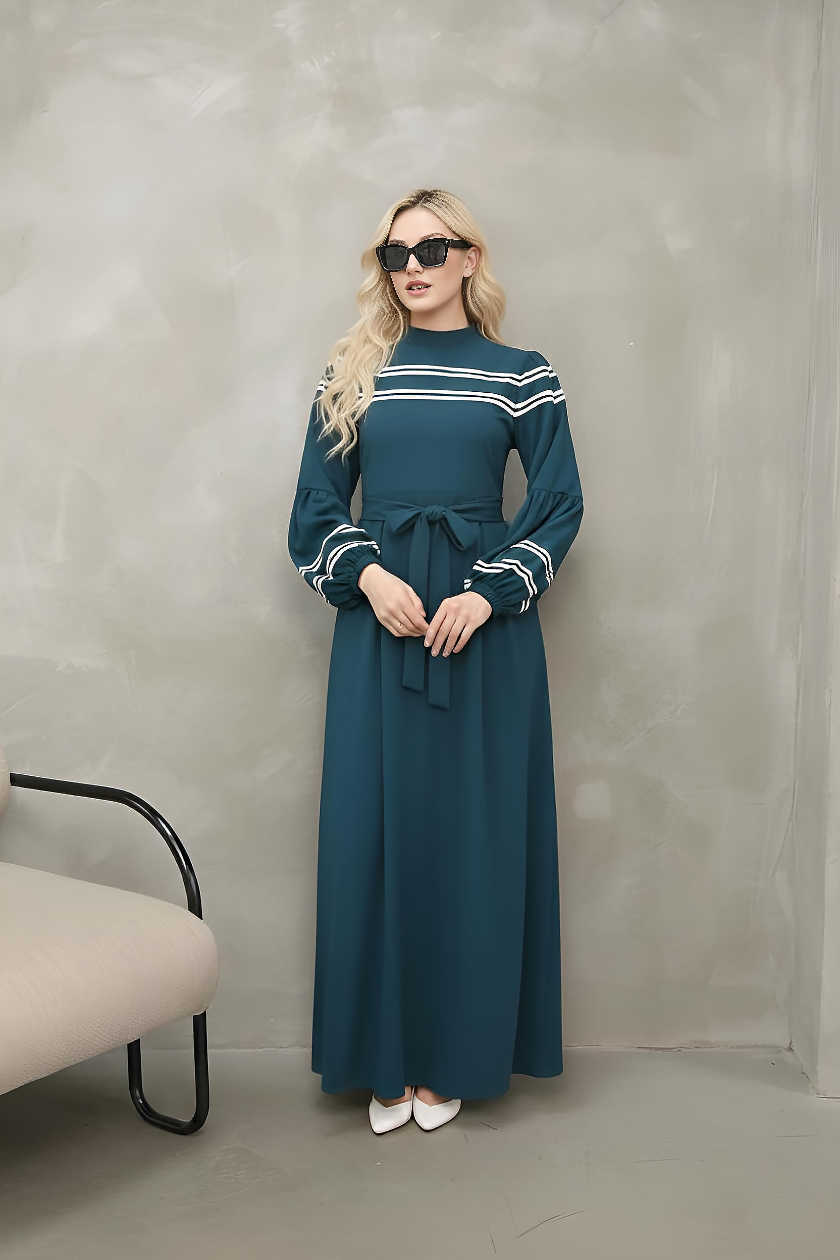 Side view of navy striped-trim maxi dress showing A-line skirt and front pleats