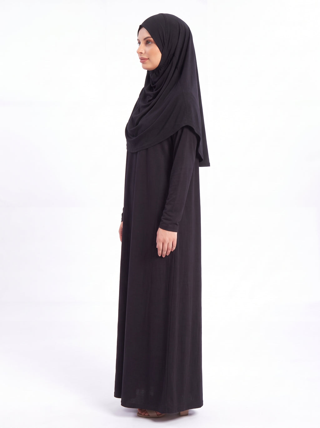 Muslim woman wearing black one piece prayer dress for salah, Hajj and Umrah