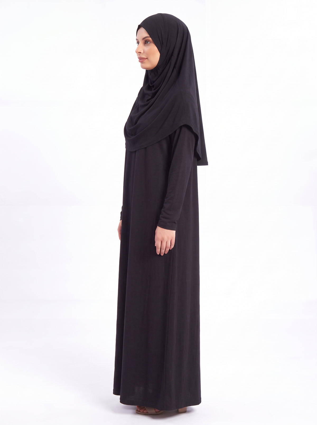 Muslim woman wearing black one piece prayer dress for salah, Hajj and Umrah