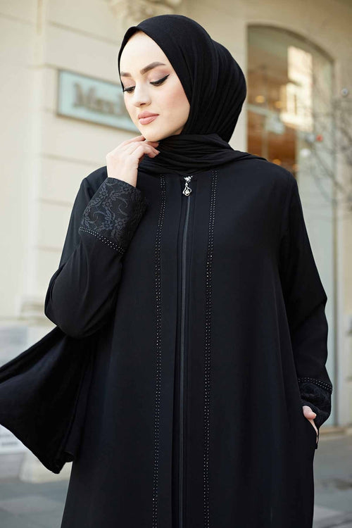 Close-up of black abaya showing stone-trim zip detail and floral lace appliqué cuff sleeve